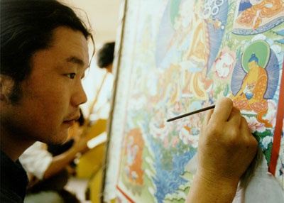 A man studies the Tibetan arts, painting Buddhist images on a canvas