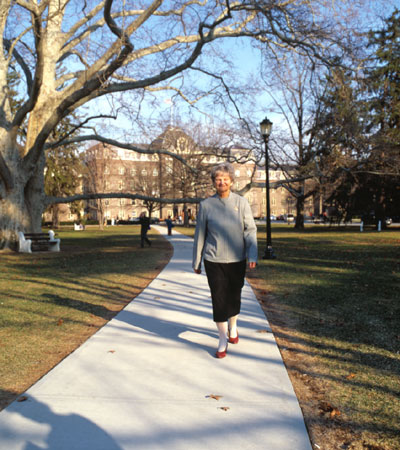 Betty Daniels walks towards the library, Main Building and the famous Vassar Tree behind her