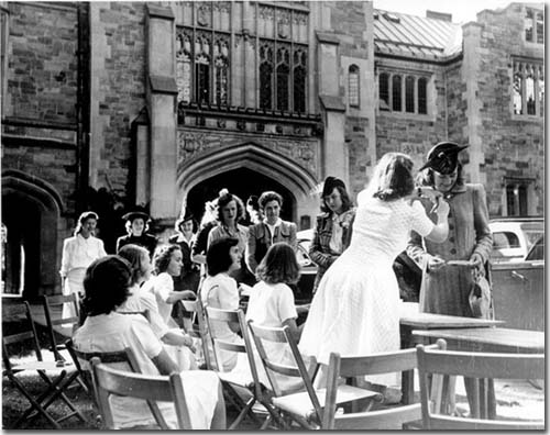a group of women sit in front of Main Gate on their first day at Vassar