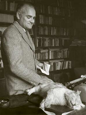Alberto Moravia in his study with his cat, Famossimo, named for the Italian author