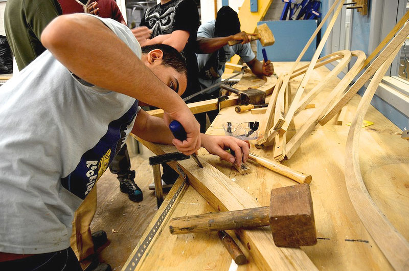 A participant attends to fine details on the boat, which will be displayed at the Mystic Seaport Museum.